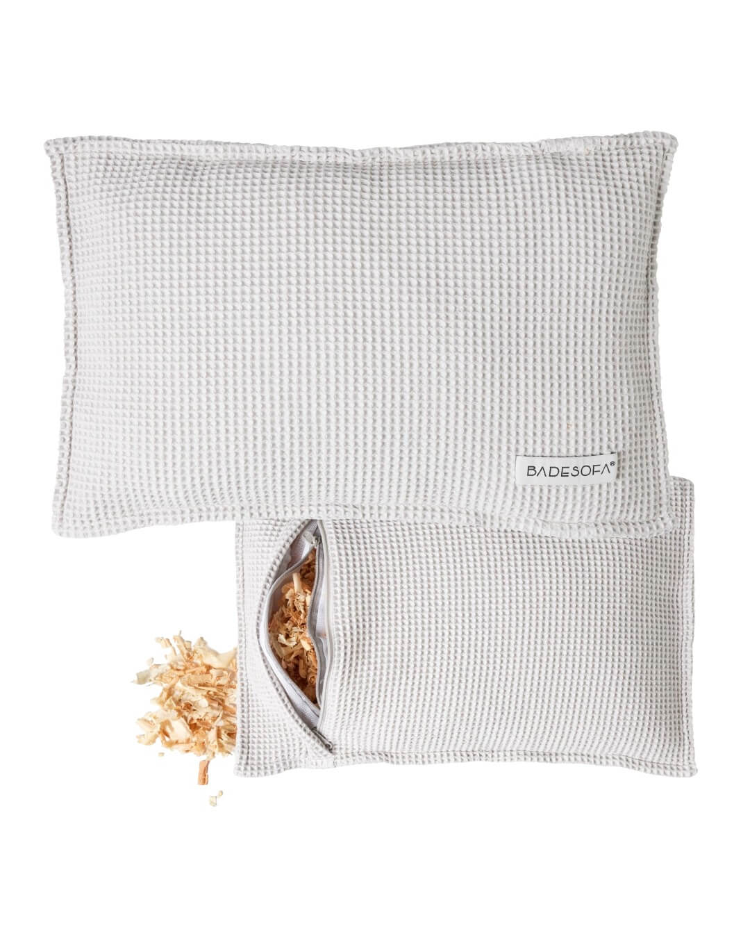 Zirbenkissen von vorne und hinten zu sehen, auf der Rückseite ist der Reißverschluss des Bezugs geöffnet und die Zirbenspäne zu sehen.